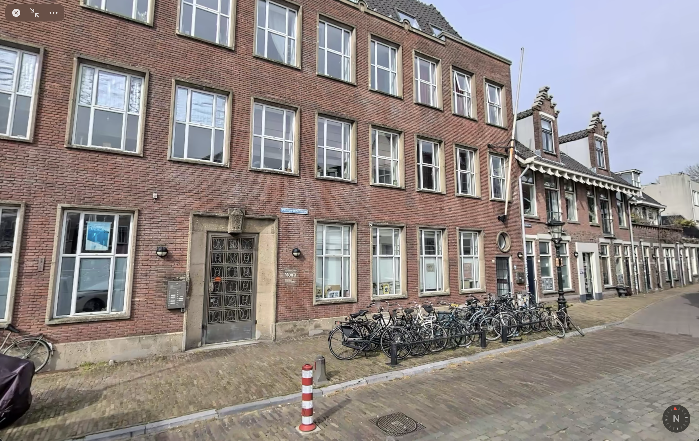 Entrance of Moira in Utrecht: a large three-floor brick building in an older architectural style and ornate metal entrance door